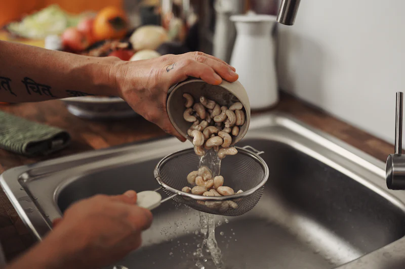 cashew nuts being strained to make plant-based milk
